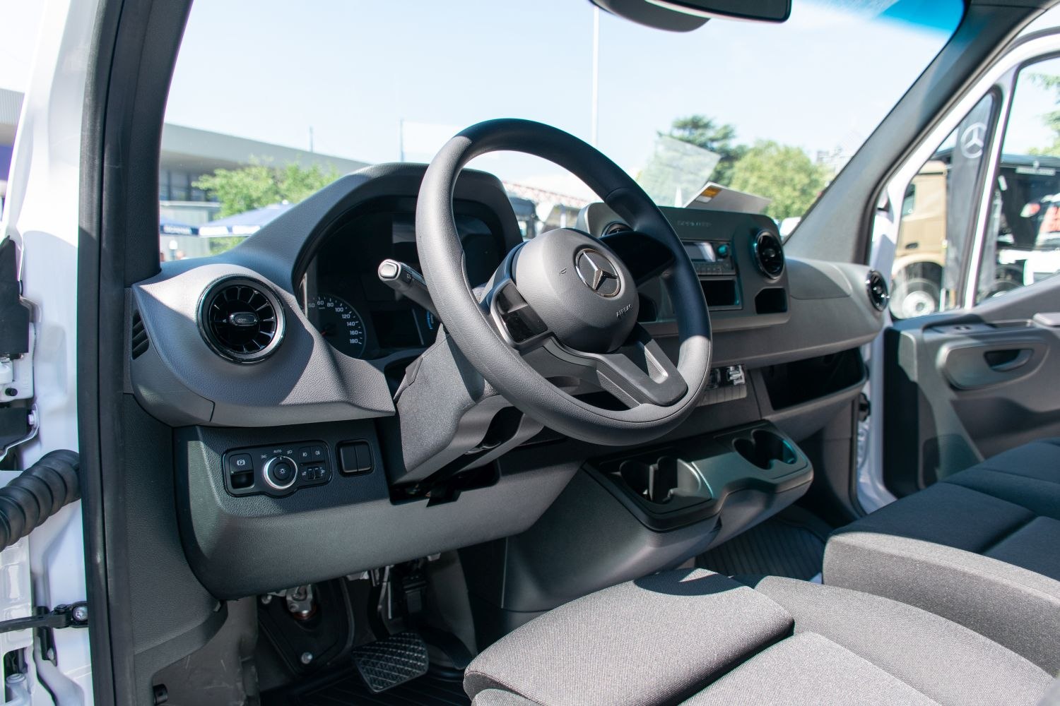 Dashboard and steering wheel with driver controls in vehicle cabin