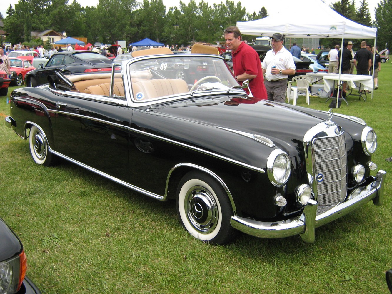 Classic convertible with black paint, chrome grille, and whitewall tires