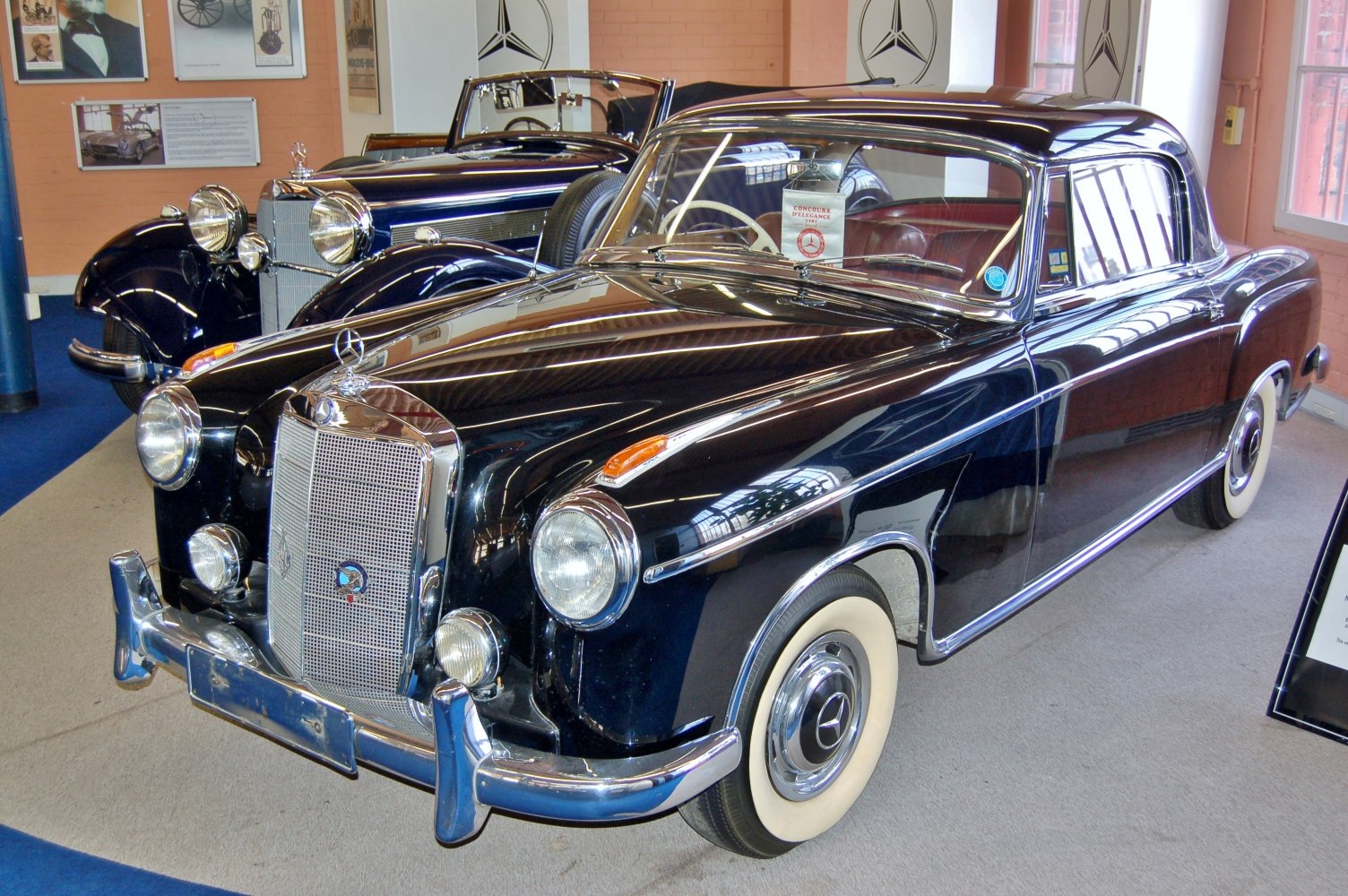 Vintage luxury coupe with chrome grille and whitewall tires