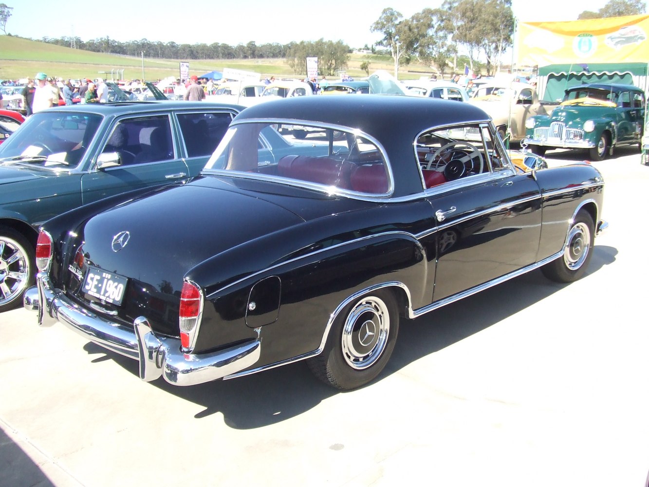Rear three-quarter view of a black vintage coupe with chrome details