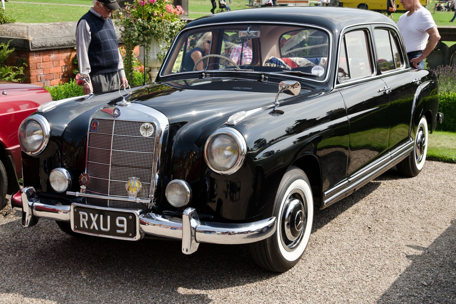 Vintage black sedan with round headlights, chrome grille, and whitewall tires.
