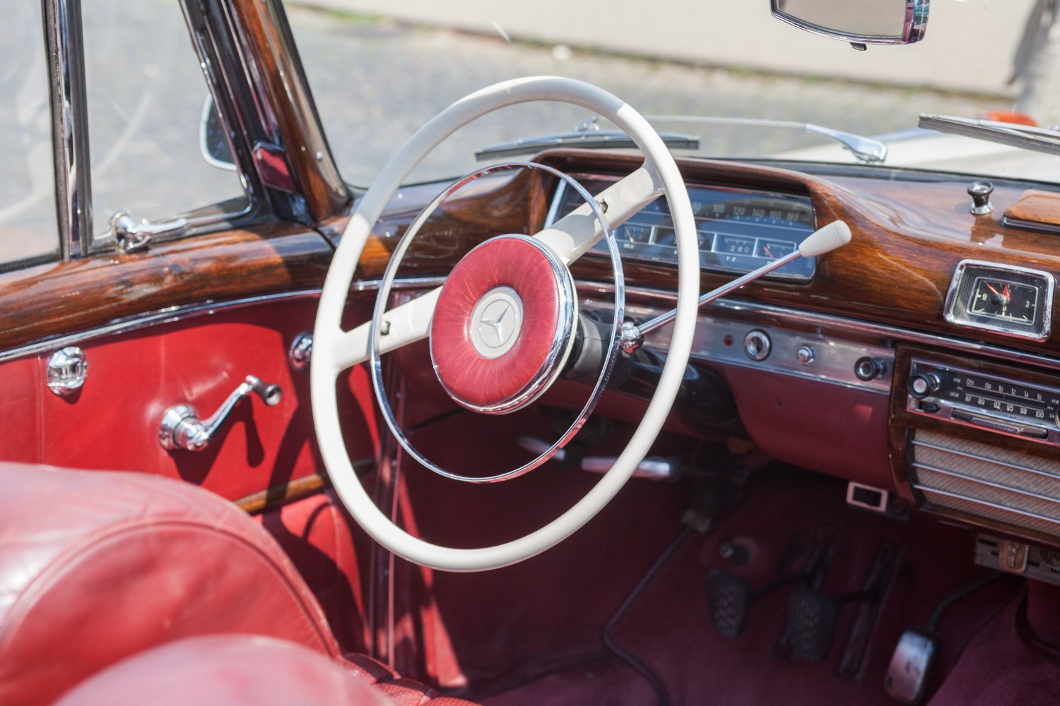 Classic vintage steering wheel and wood-trimmed dashboard with retro controls.