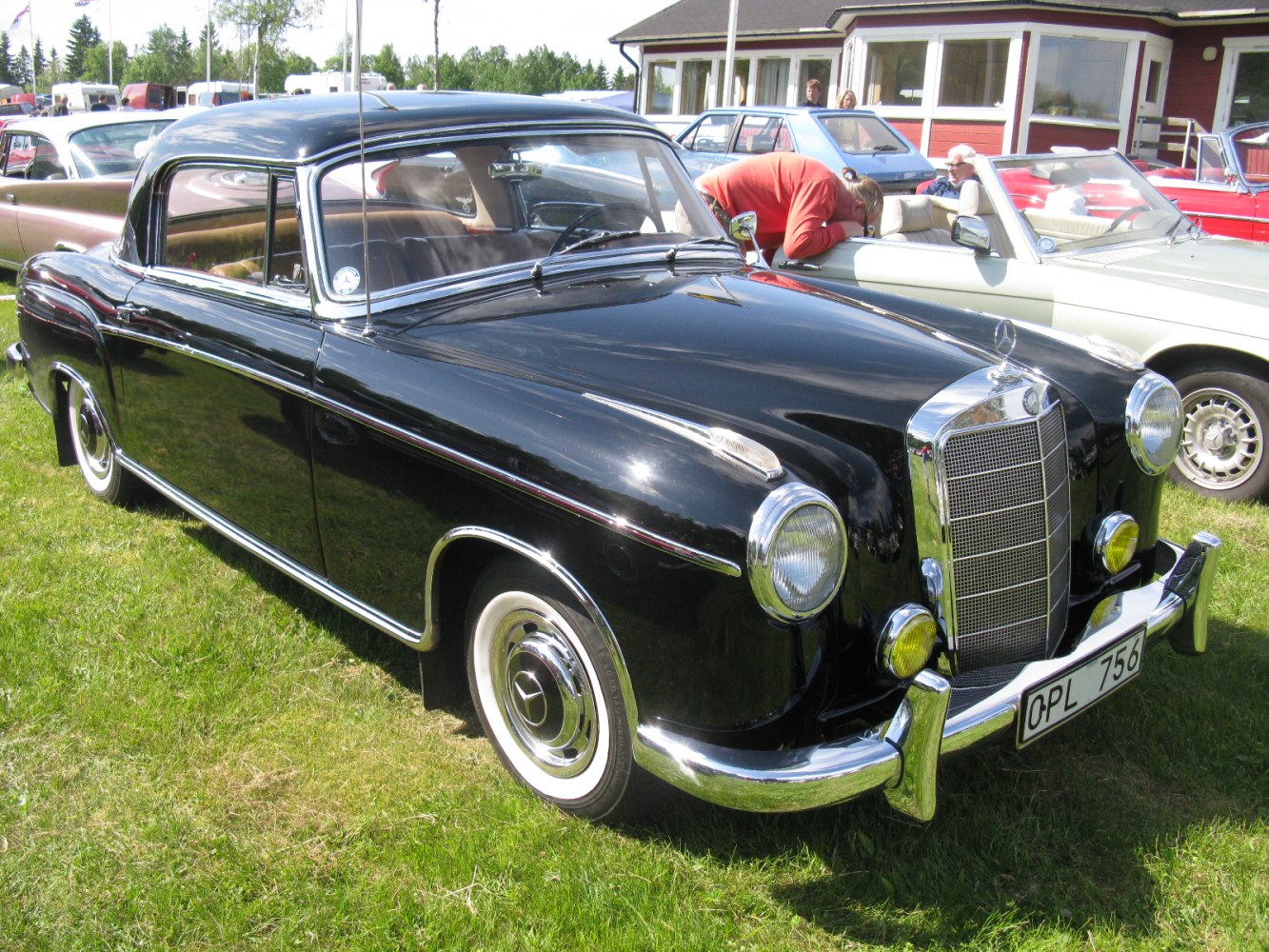 1950s luxury coupe with chrome grille and round headlights