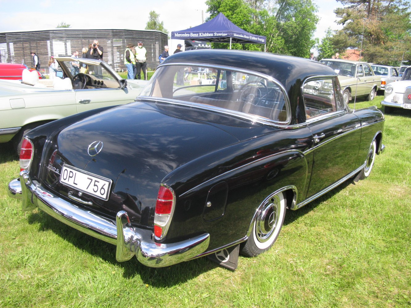 Rear and side view of vintage coupe with chrome bumper and rounded design