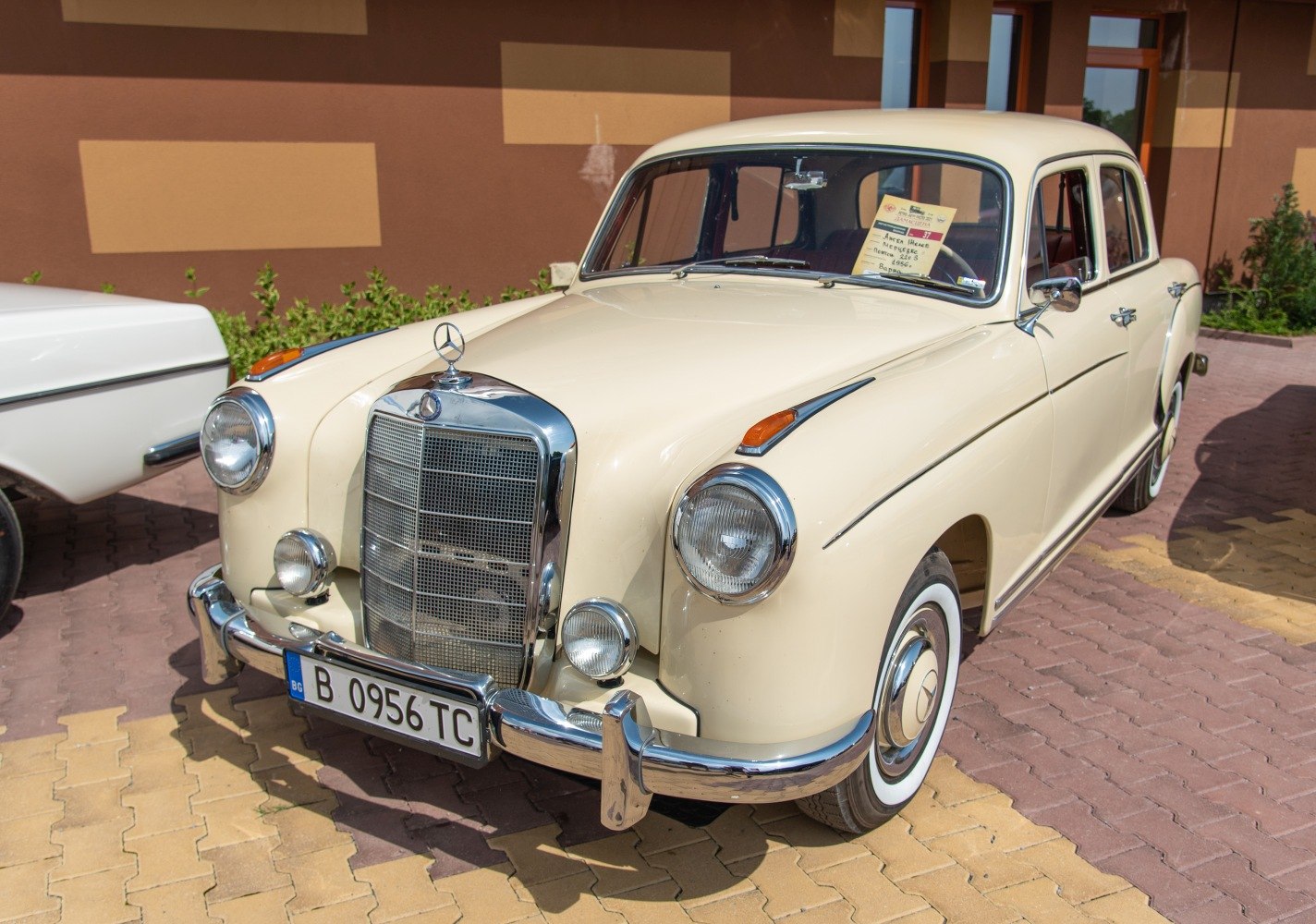 Rounded headlights, chrome grille, front fender turn signals, whitewall tires