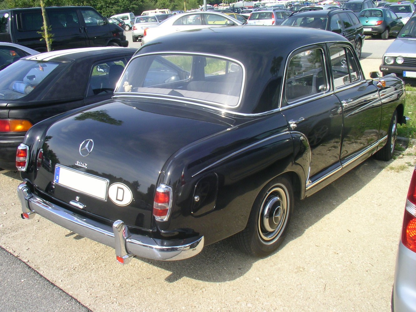 Rear view of vintage 1950s sedan with rounded body and chrome bumper