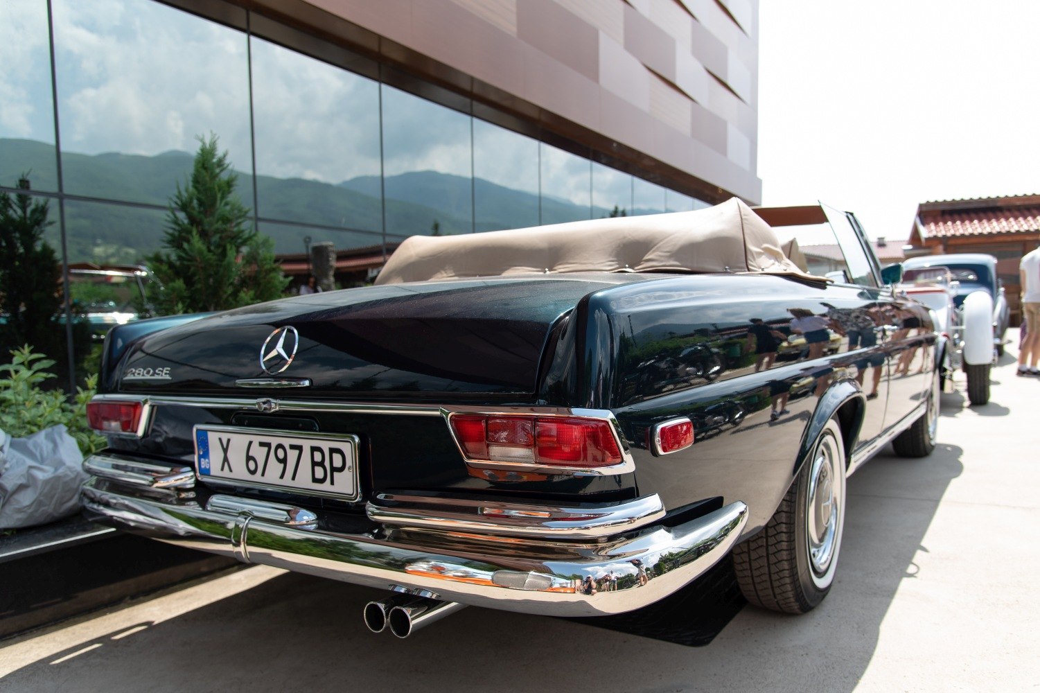 Rear view of a classic convertible with dual exhaust and chrome bumper