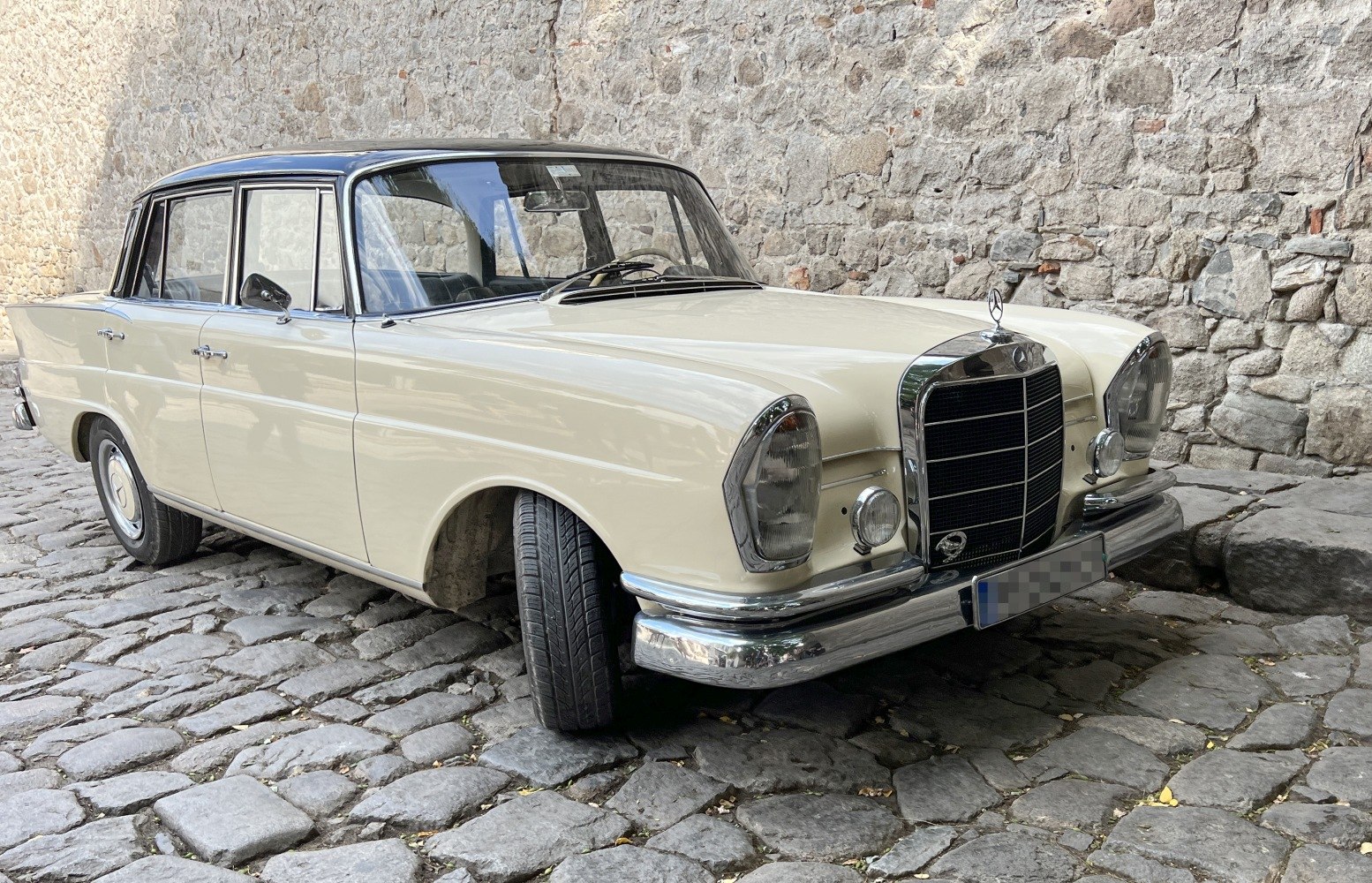 Front view with chrome grille, rounded headlights, and smooth body lines