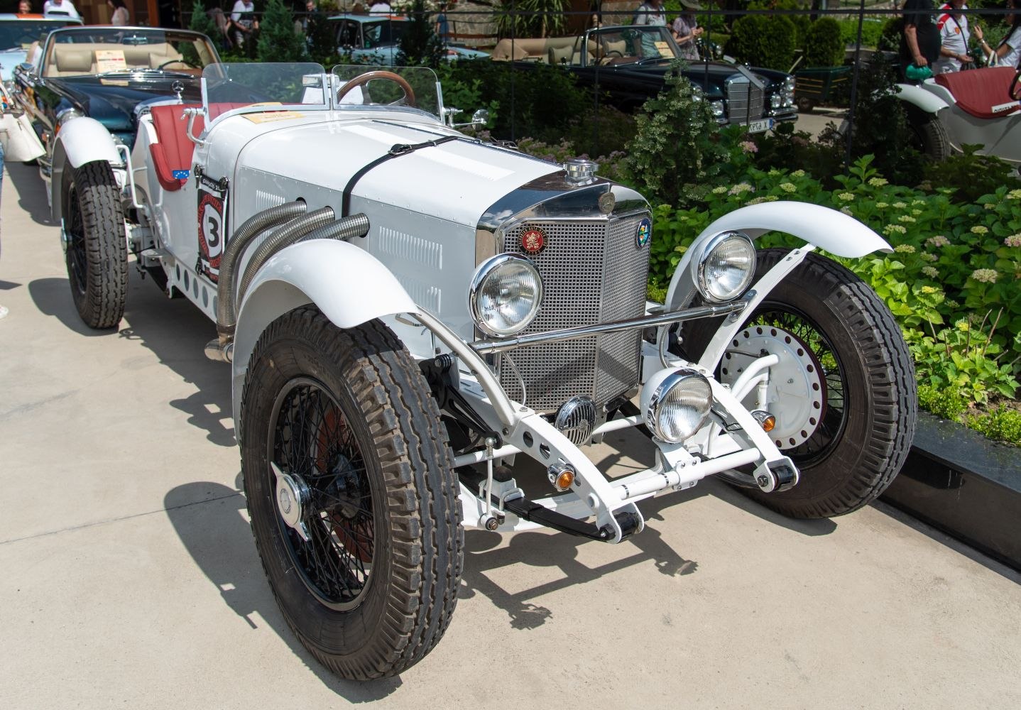 Vintage racing car with external exhaust pipes and wire-spoke wheels