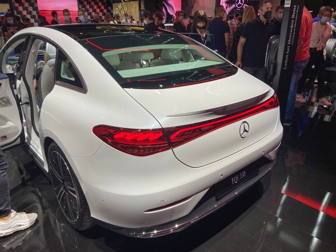 Sleek rear design with continuous LED taillights and rear spoiler on white electric sedan