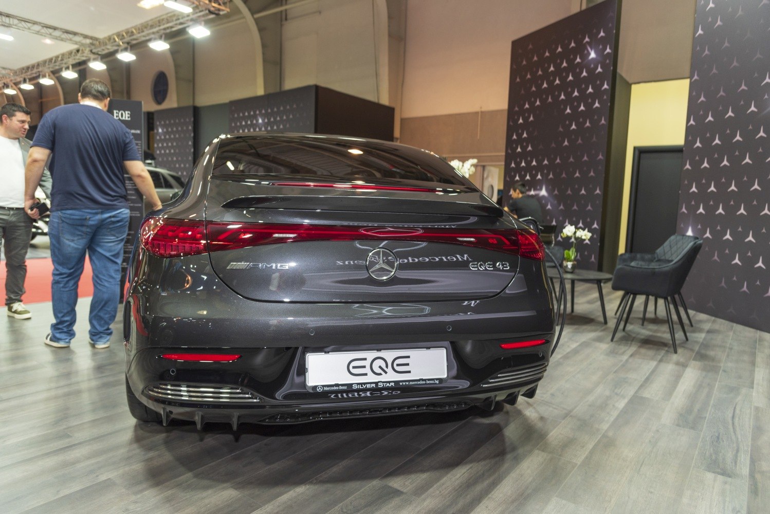 Rear view of sleek sedan with continuous LED tail light bar and rear spoiler
