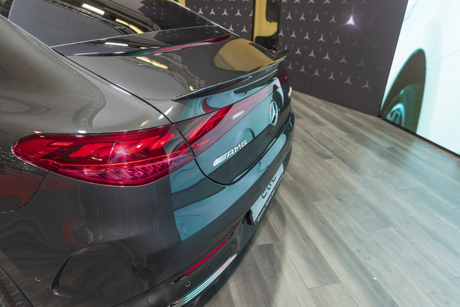 Close-up of rear tail light and AMG badge on dark electric sedan