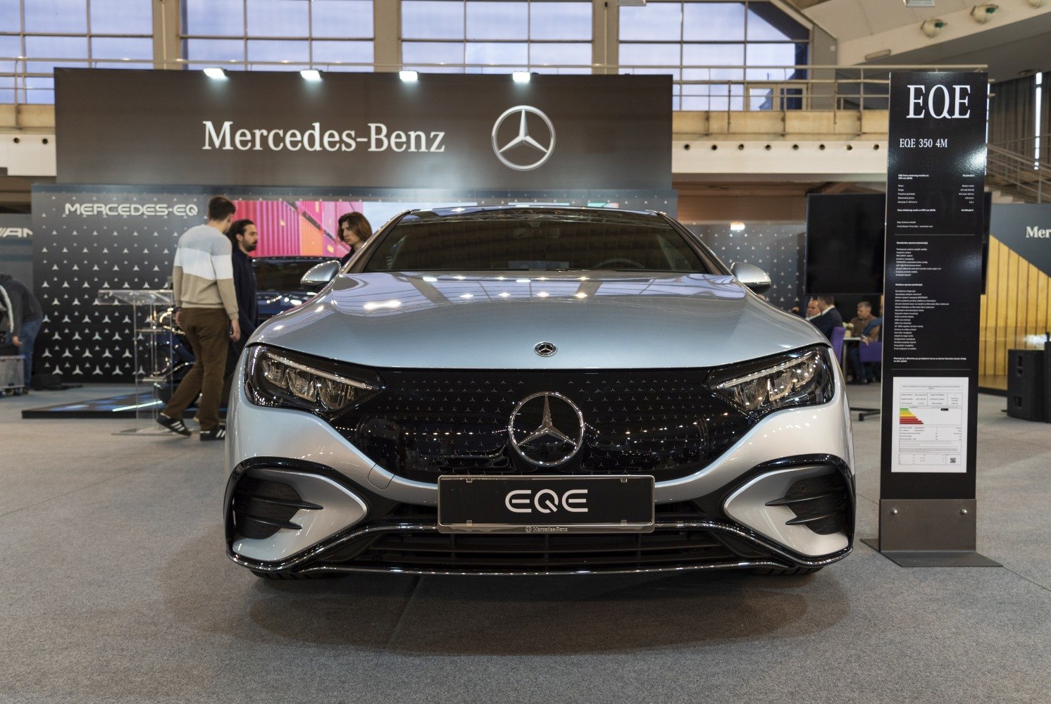 Front view of electric sedan with LED headlights and bold grille.