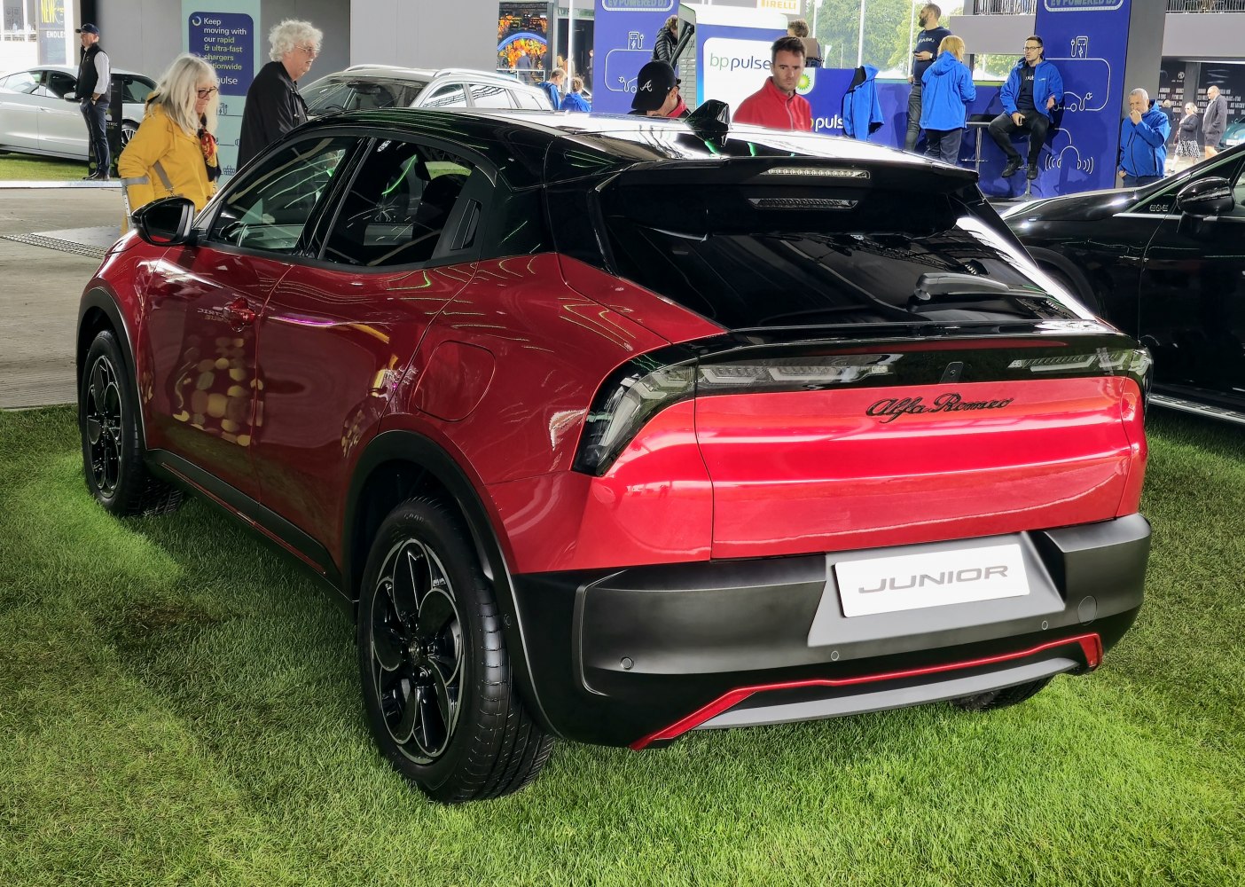 Rear view of modern compact SUV with black roof and red body