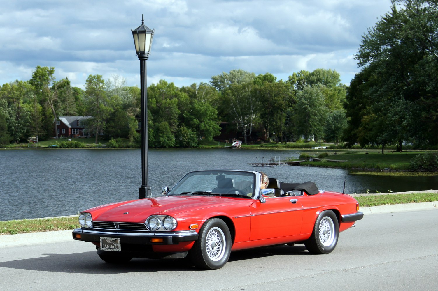 Red convertible with dual round headlights and wire-spoke wheels