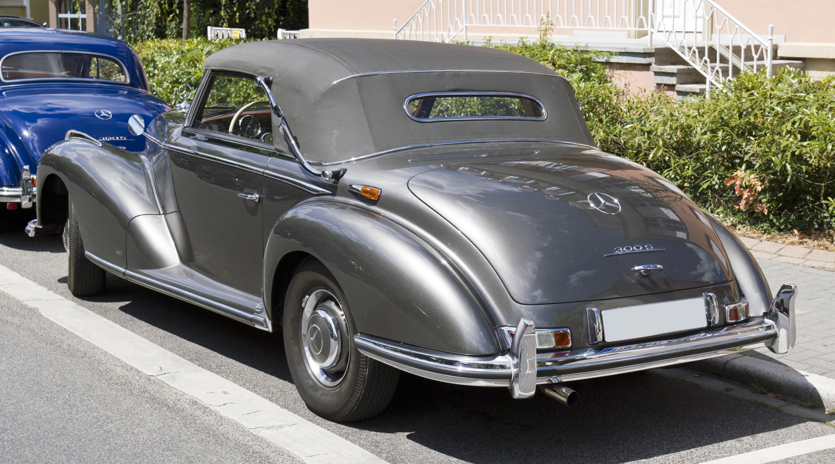 Convertible car with soft top, rounded rear fenders, and chrome bumper