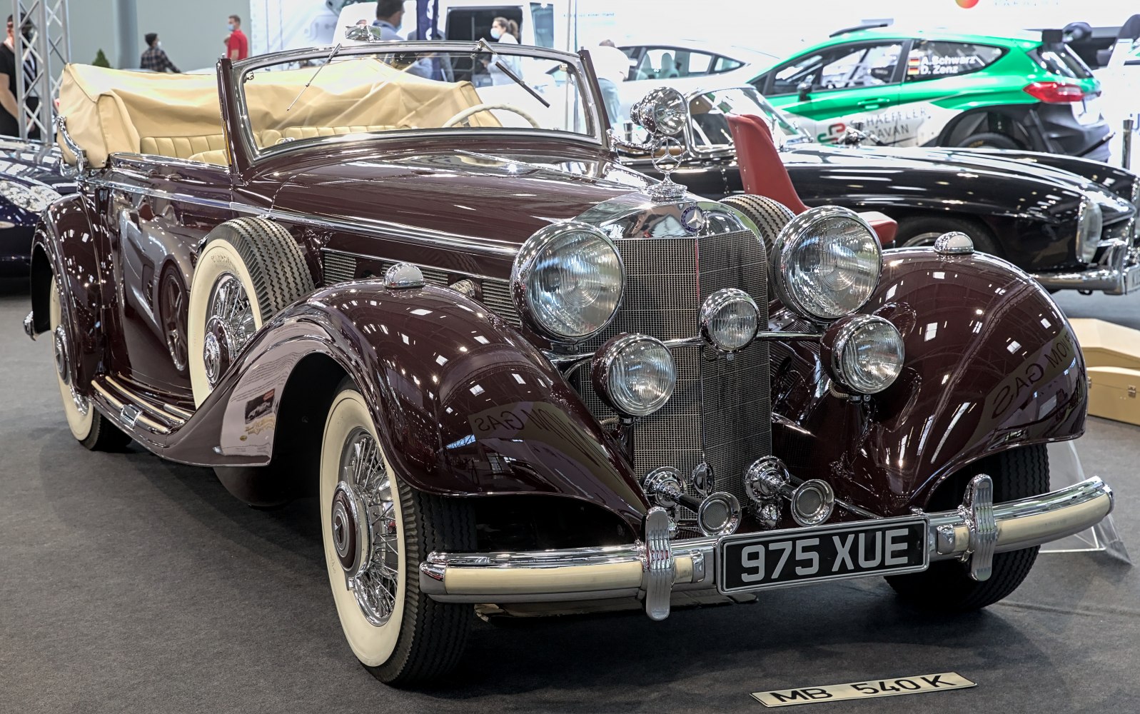Classic vintage convertible with dual side spare tires and prominent chrome headlights