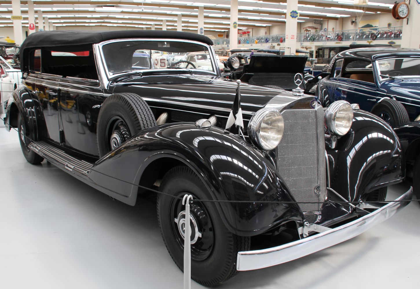 Long wheelbase vintage sedan with soft top and dual spare tires