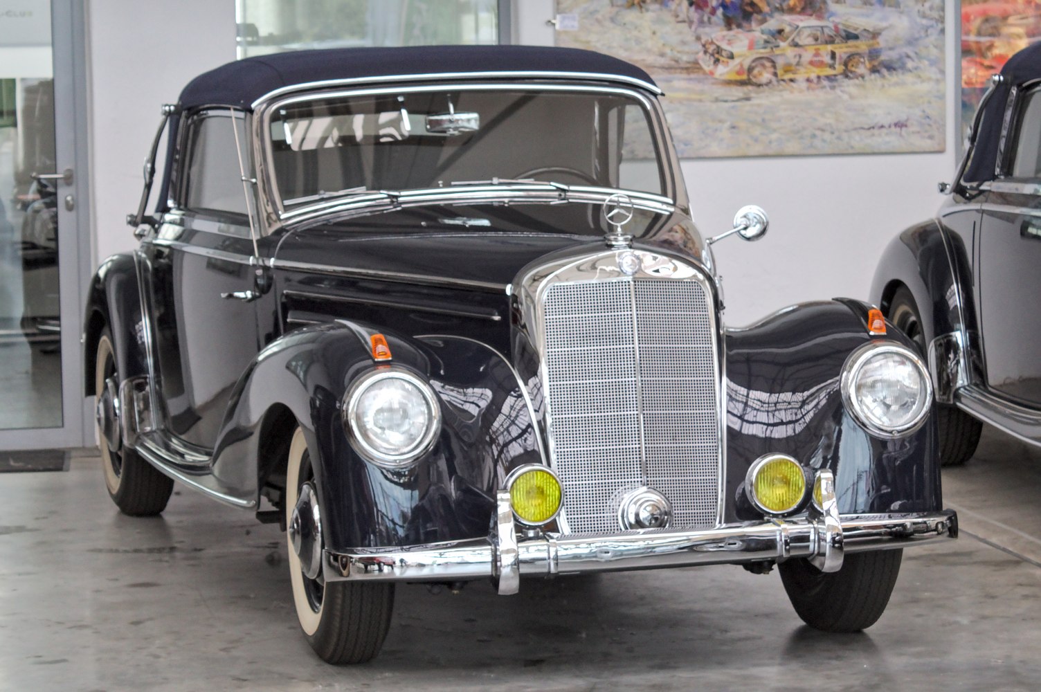 Vintage convertible with rounded headlights and chrome grille