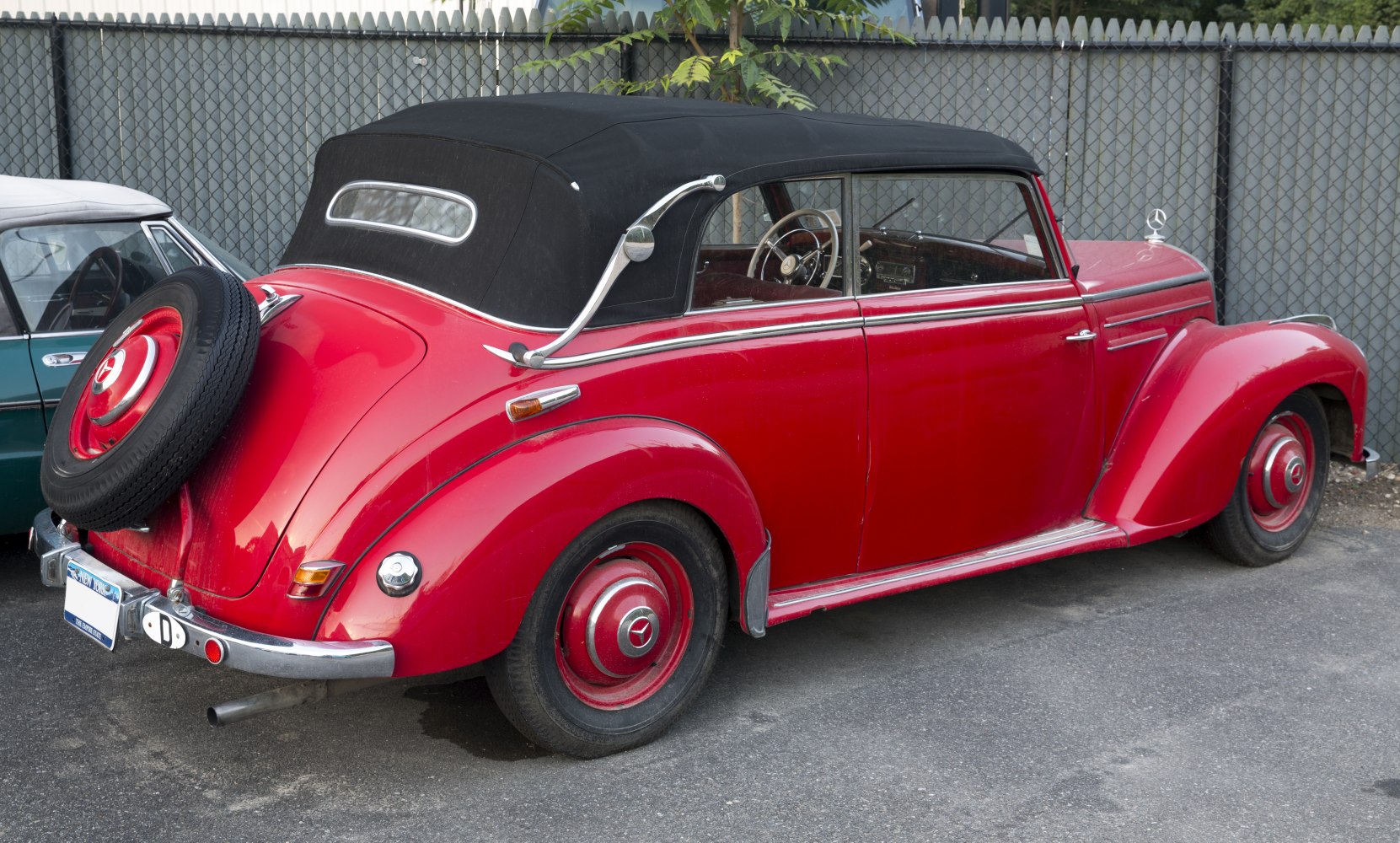 Vintage convertible with rear spare wheel and black canvas roof