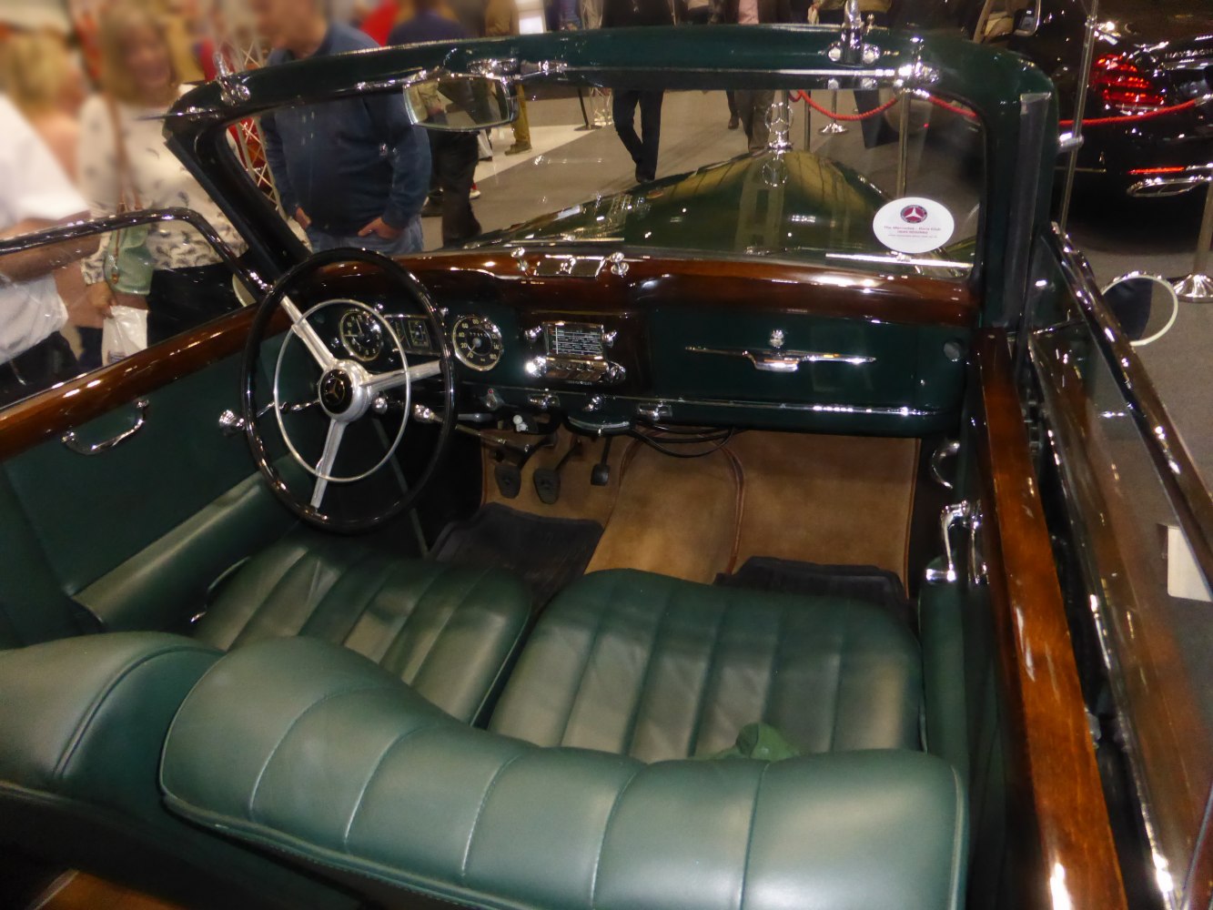 Vintage convertible interior with green leather seats and wooden trim