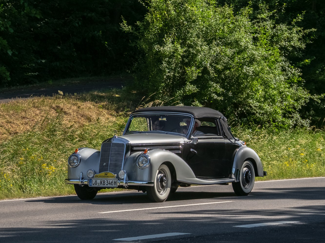 Vintage convertible with rounded fenders and black soft top