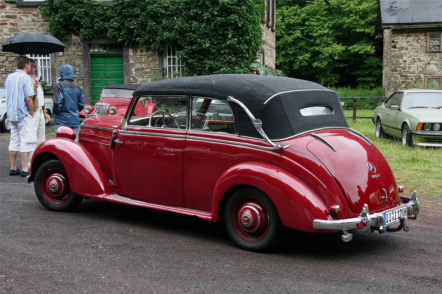 Red convertible with black soft top, detailed side and rear view