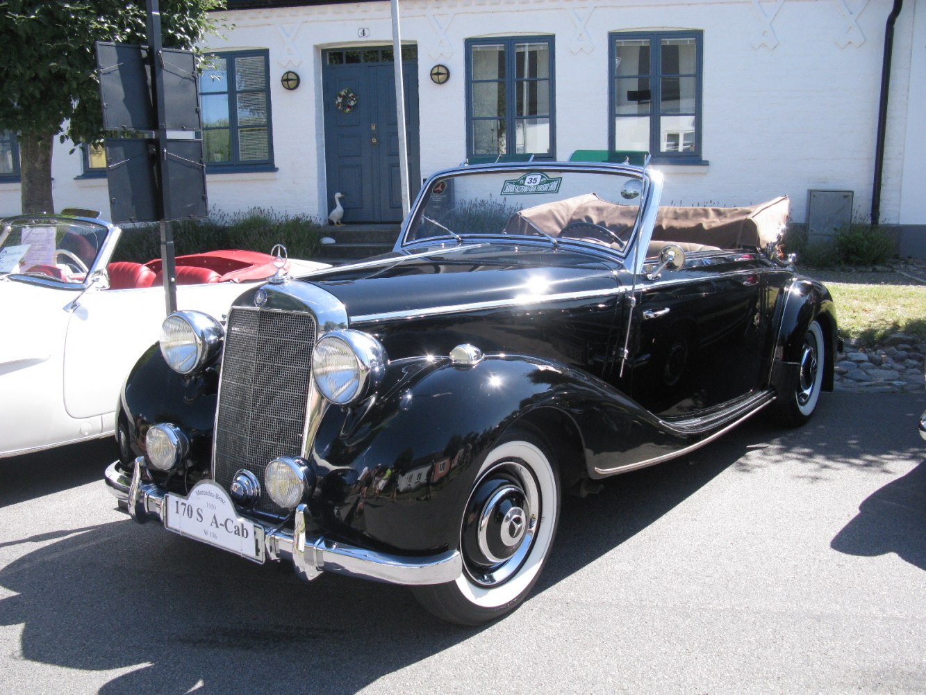 Vintage convertible with large chrome grille and wide whitewall tires
