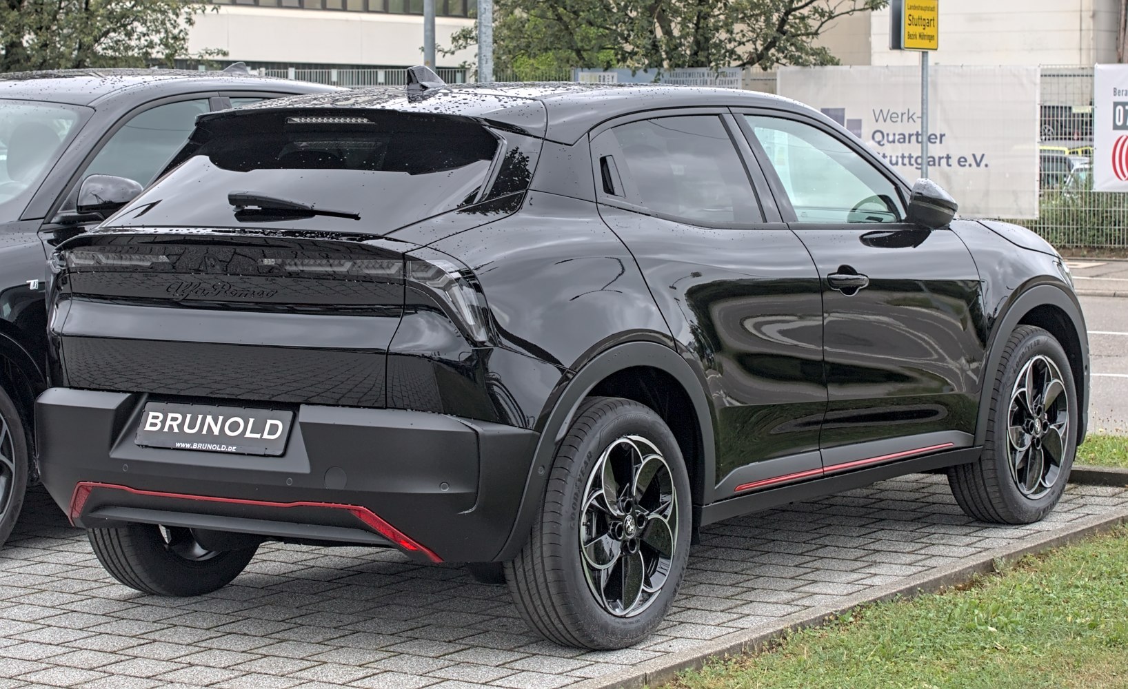 Rear and side view of black vehicle showcasing taillights and alloy wheels