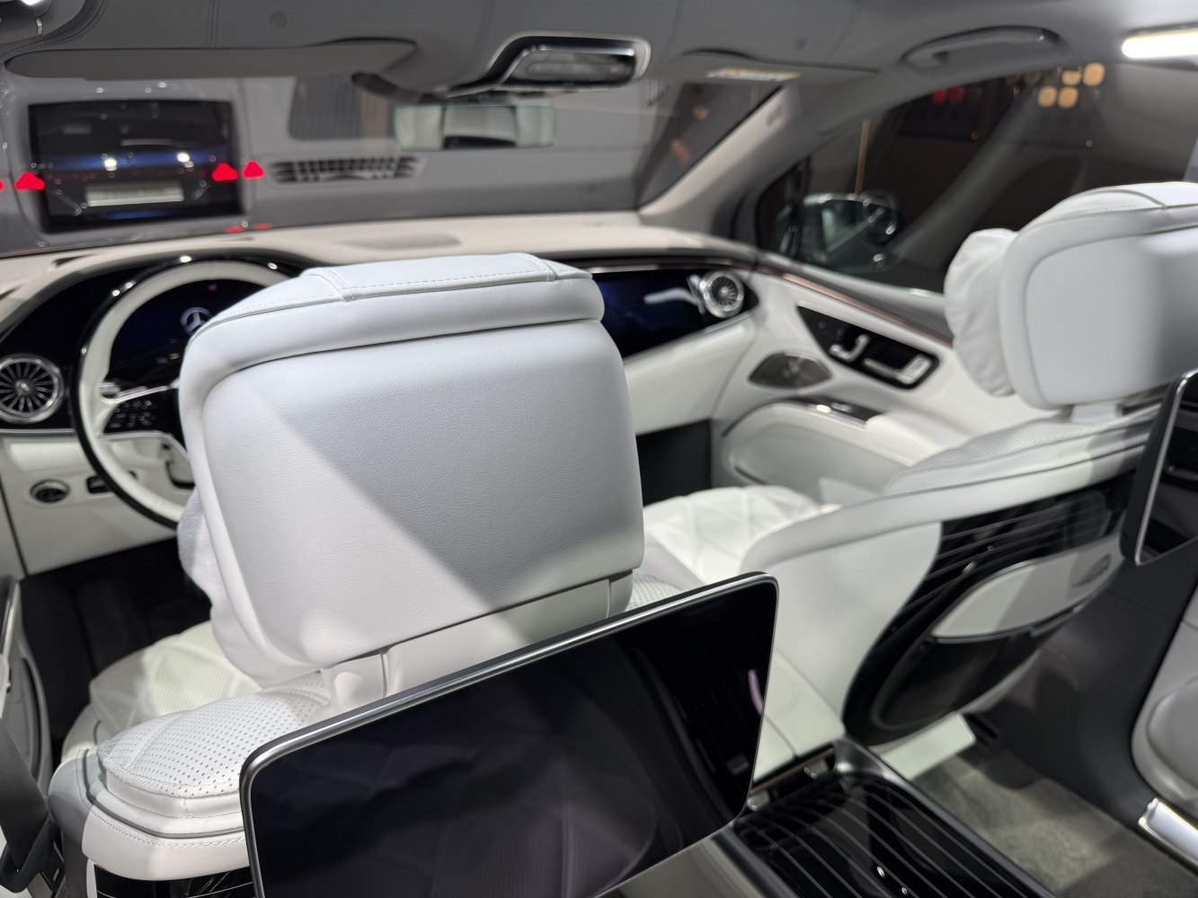 White leather interior with digital displays and rear-seat entertainment screen