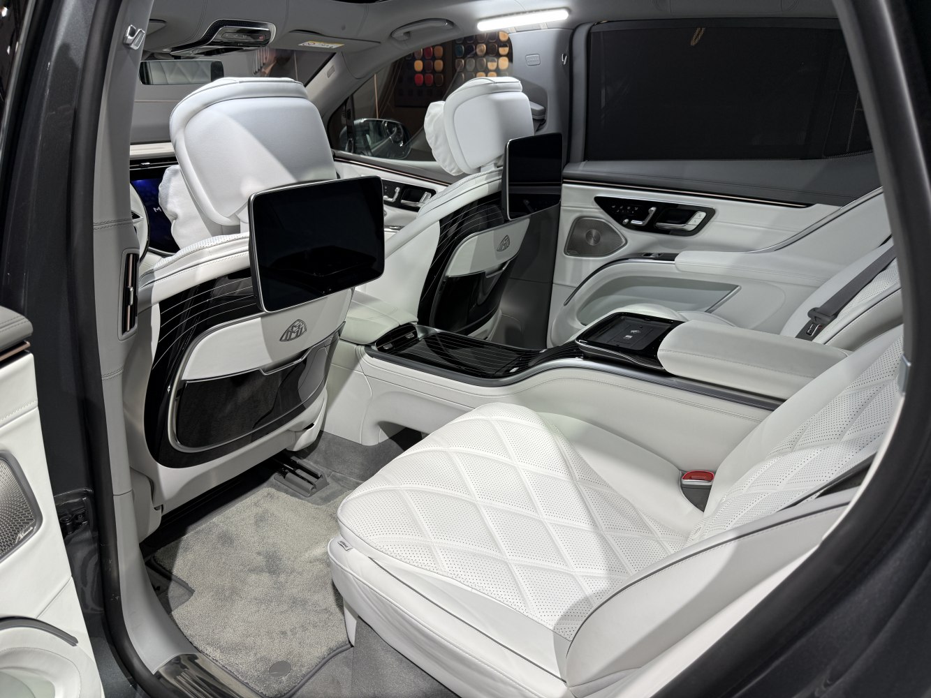 Luxury rear seats with white leather upholstery and dual rear entertainment screens