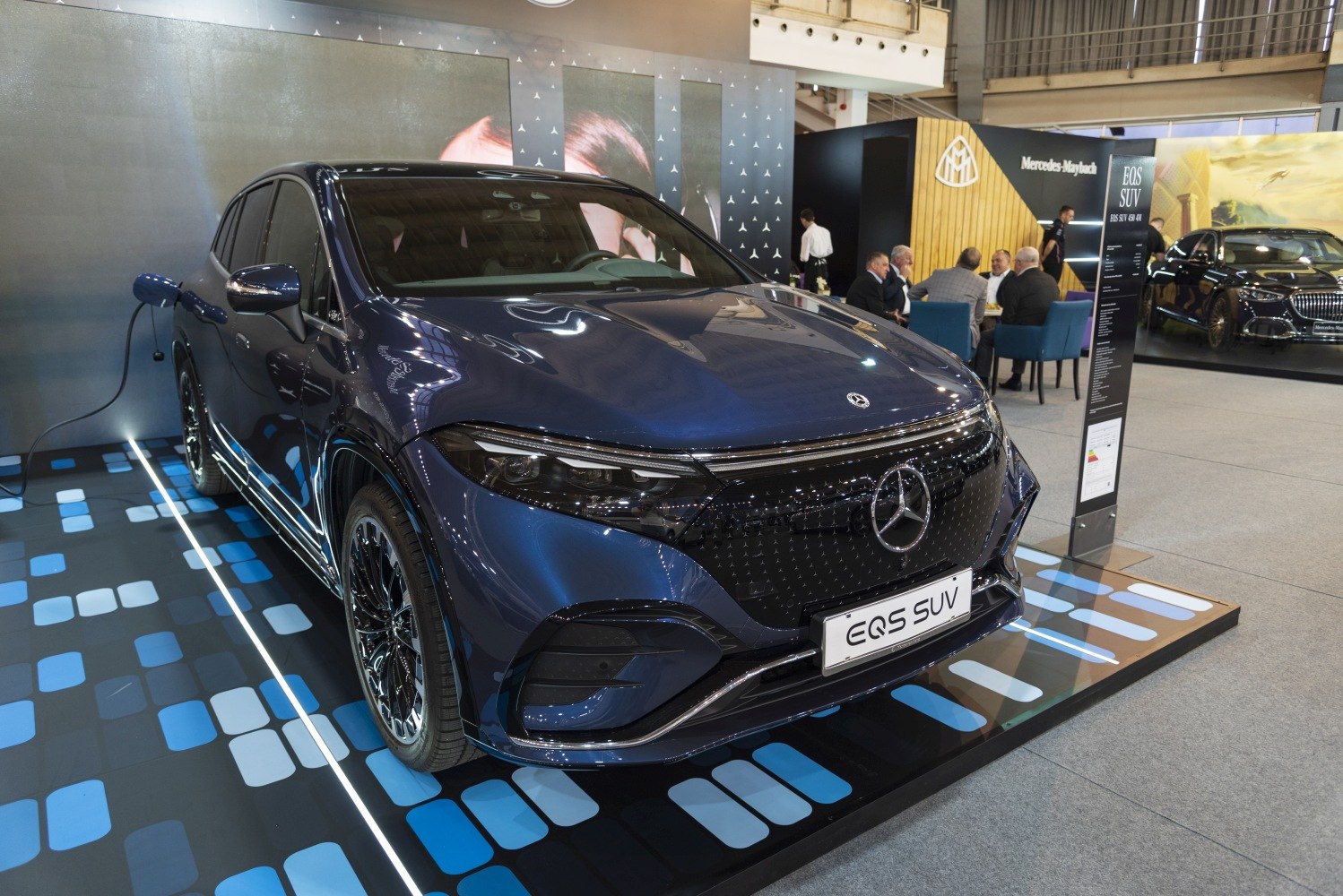 Modern electric SUV front with sleek grille and charging plug
