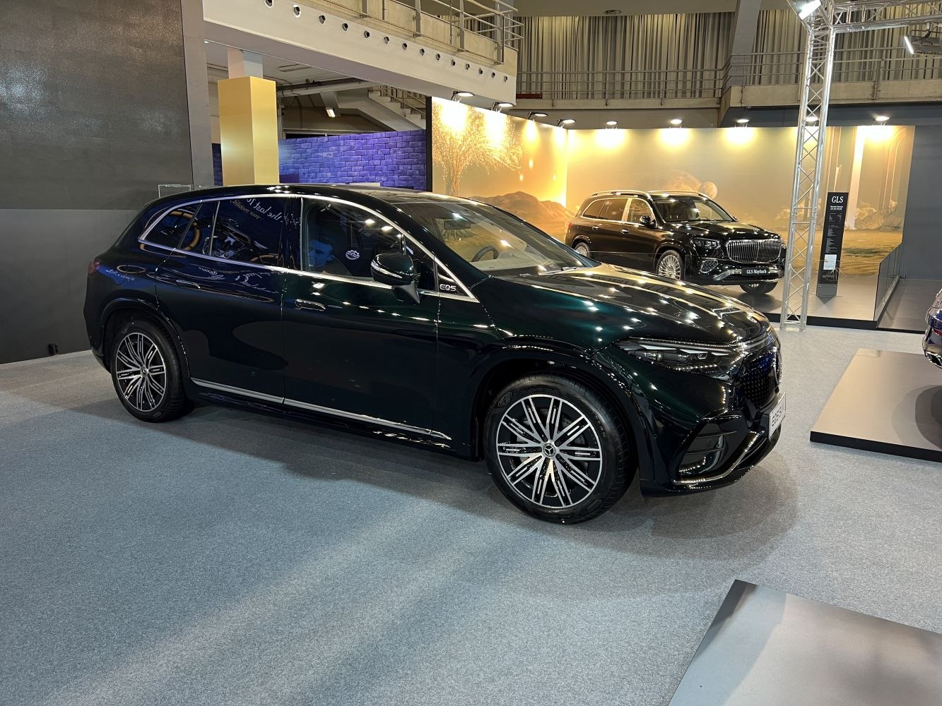 Front side profile of a luxury electric SUV with LED headlights and alloy wheels.