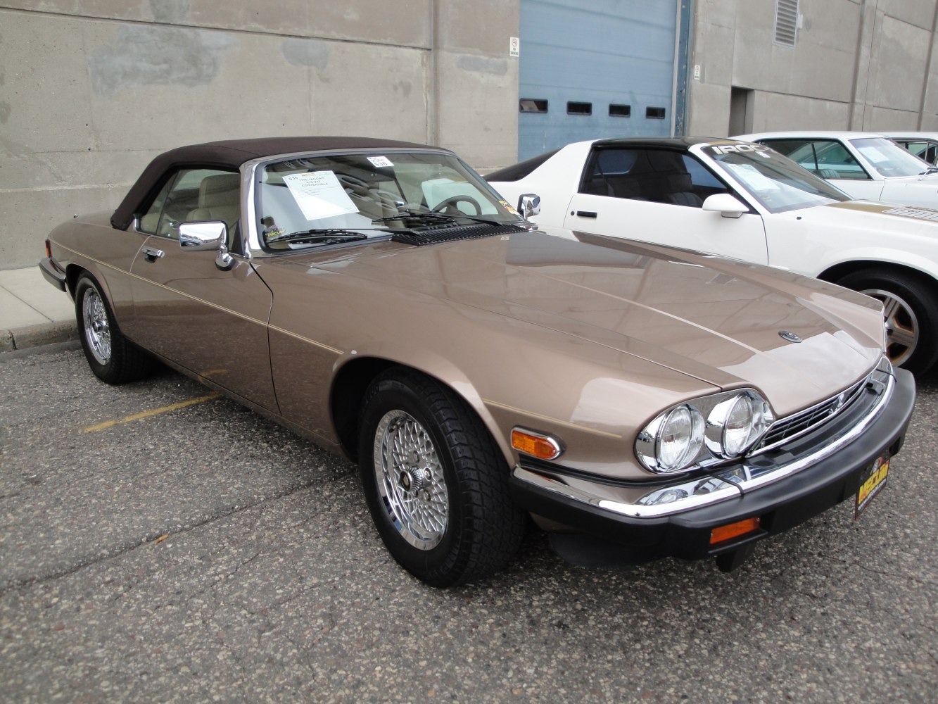 Brown soft-top convertible with wire spoke wheels and chrome details.
