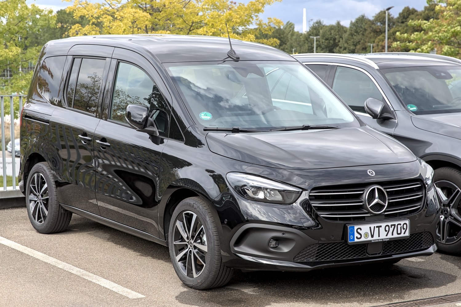 Front and side view of MPV with modern headlights and panoramic windows