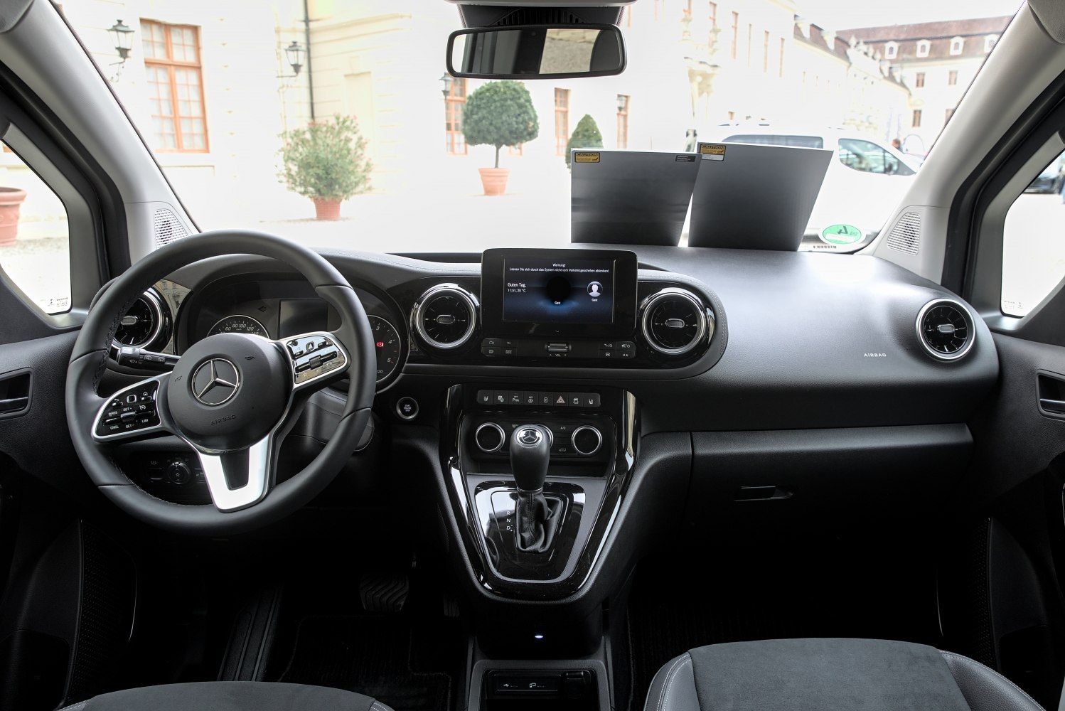 Interior dashboard with touchscreen, steering wheel controls, and gear shift lever