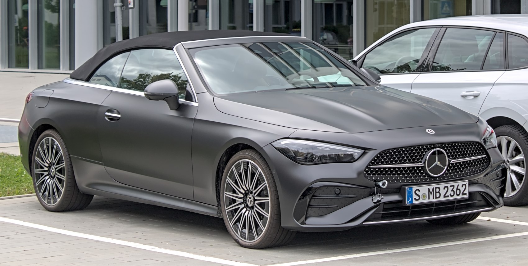 Convertible with soft top roof and alloy wheels, front angle view.