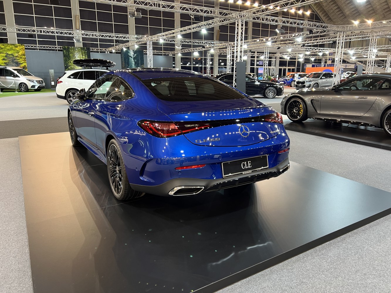 Rear view of blue luxury coupe showcasing sleek tail lights and sporty design.