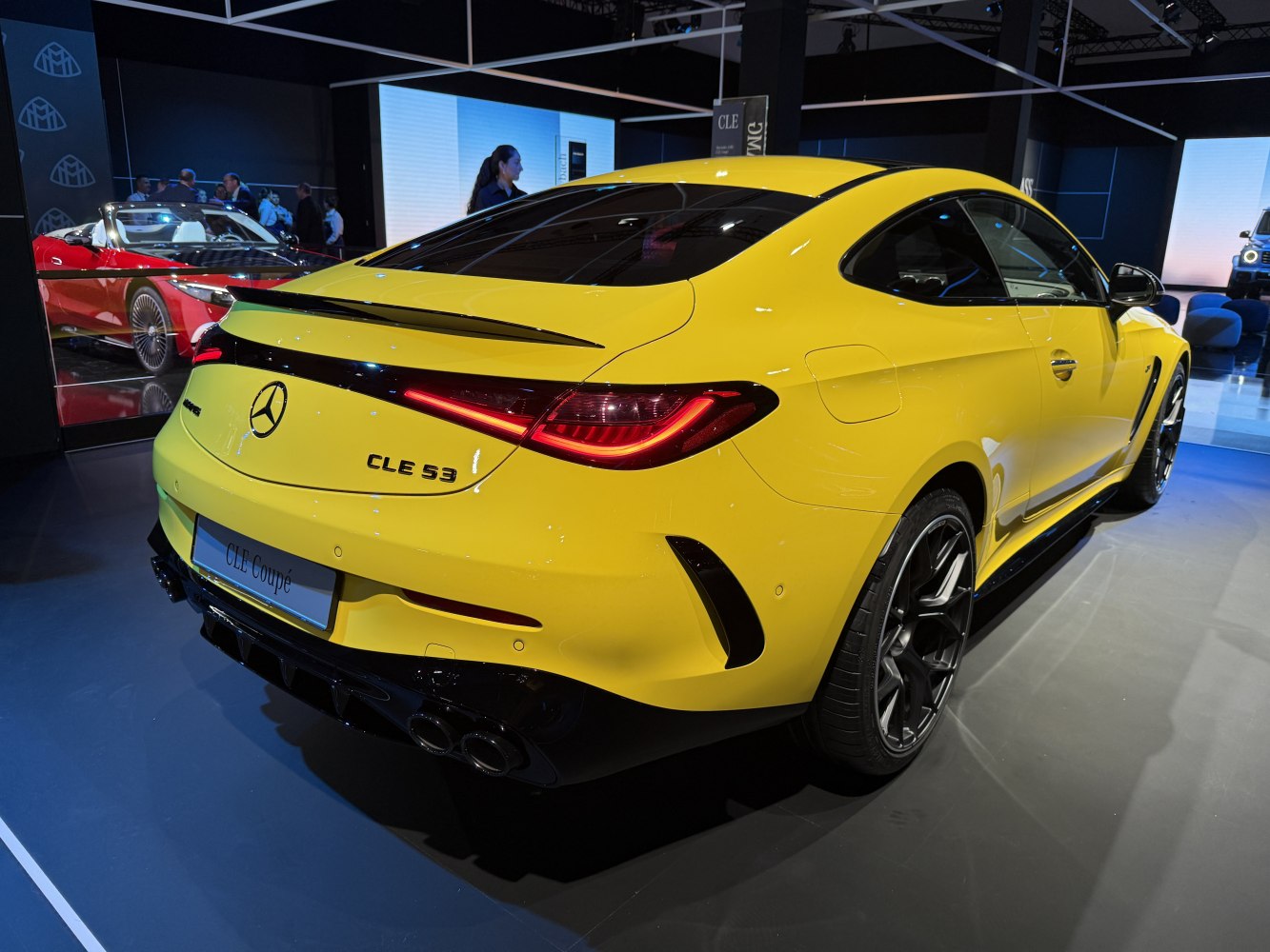 Rear view of a yellow coupe with modern taillights and quad exhaust