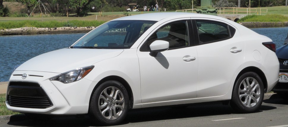 White compact sedan with large grille and alloy wheels