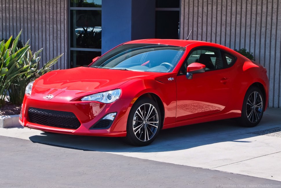 Red compact sporty coupe with aerodynamic front and alloy wheels