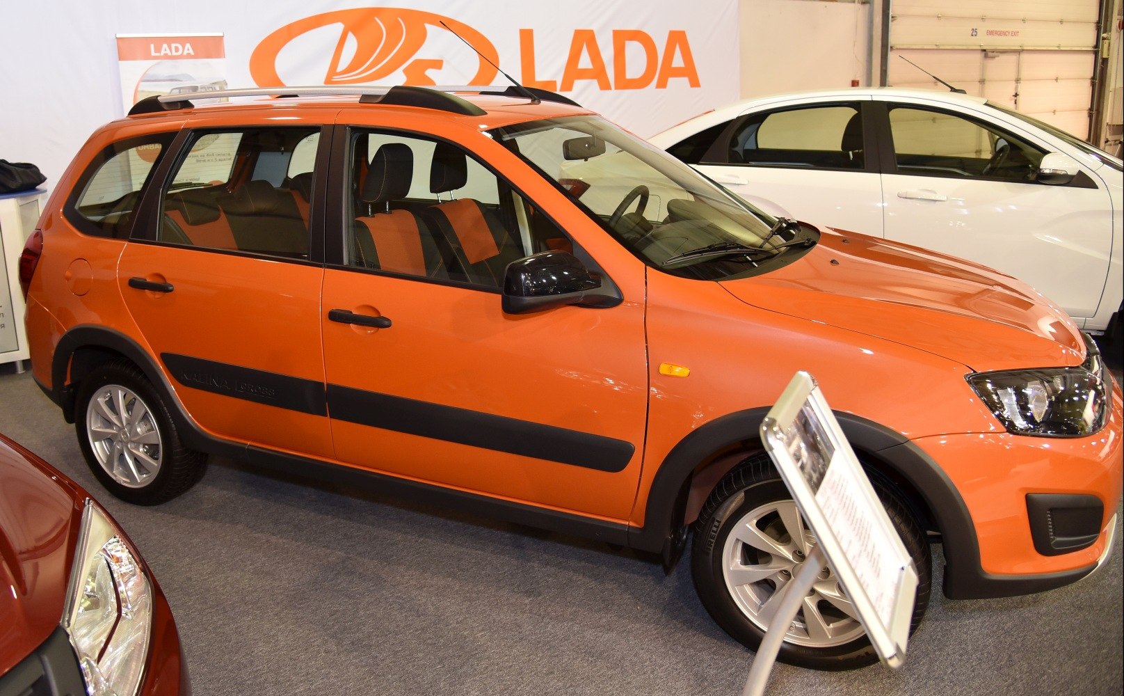 Orange SUV showcasing roof rails, black cladding, and alloy wheels