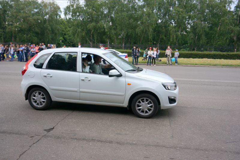 Side view of white hatchback with multi-spoke wheels and compact body