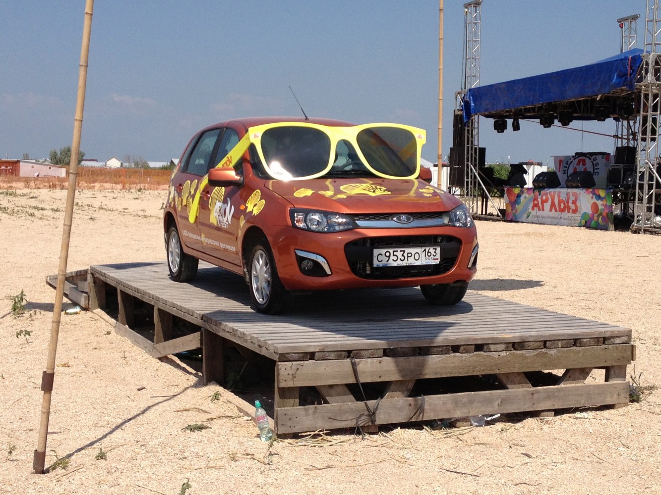 Car with large yellow sunglasses decoration and yellow decals on hood and doors