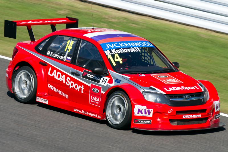 Aerodynamic red racing car with large rear wing on track