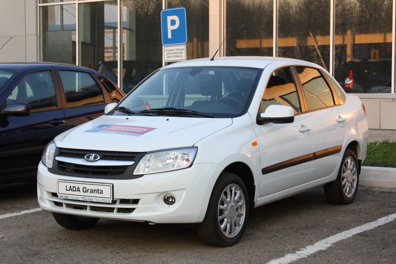 Front and side view of white sedan with alloy wheels and modern headlight design