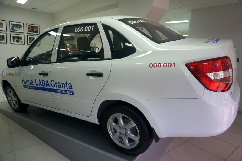 White compact sedan with visible rear lights and side profile