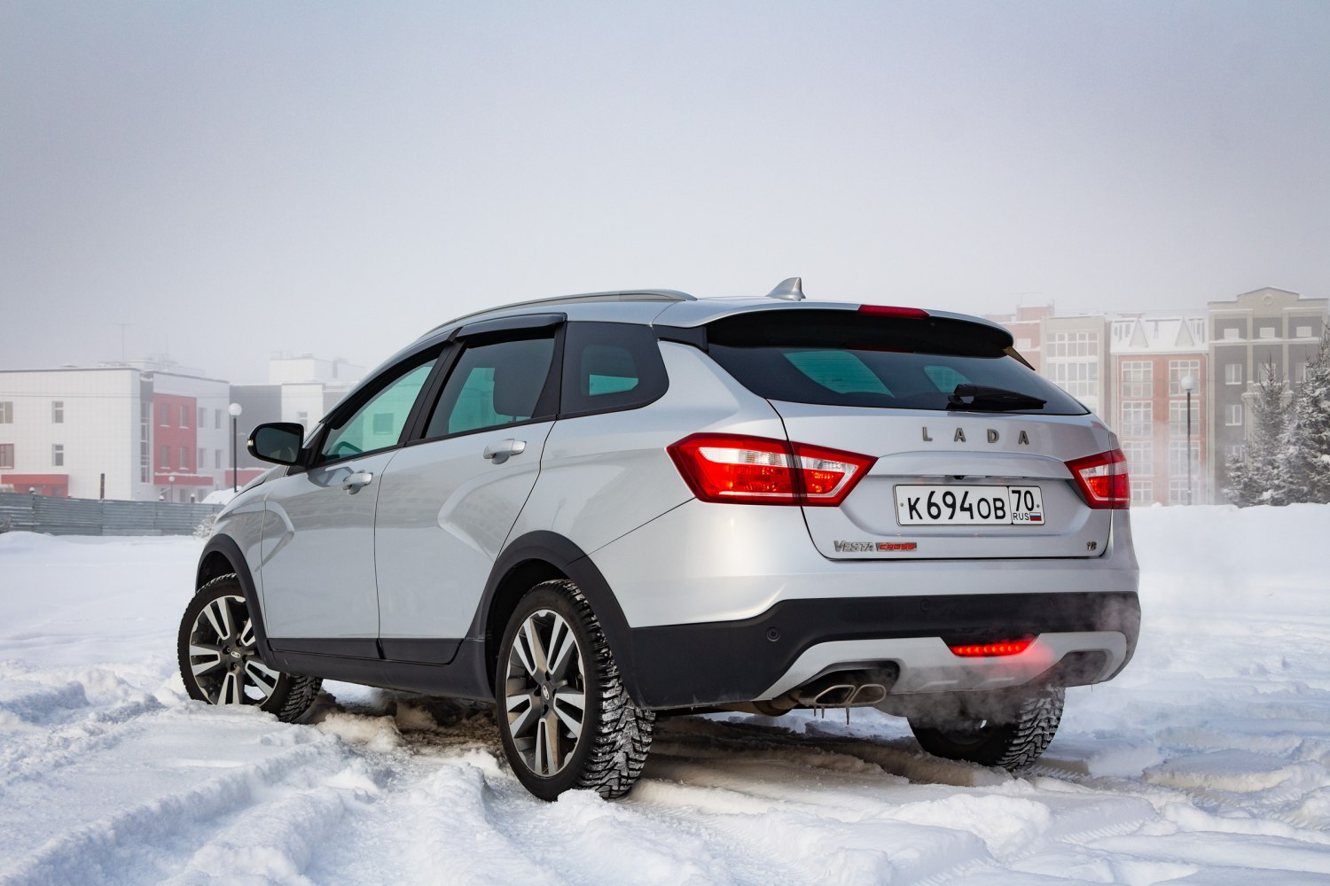 Rear view with tail lights, dual exhaust, rugged winter tires on snowy road