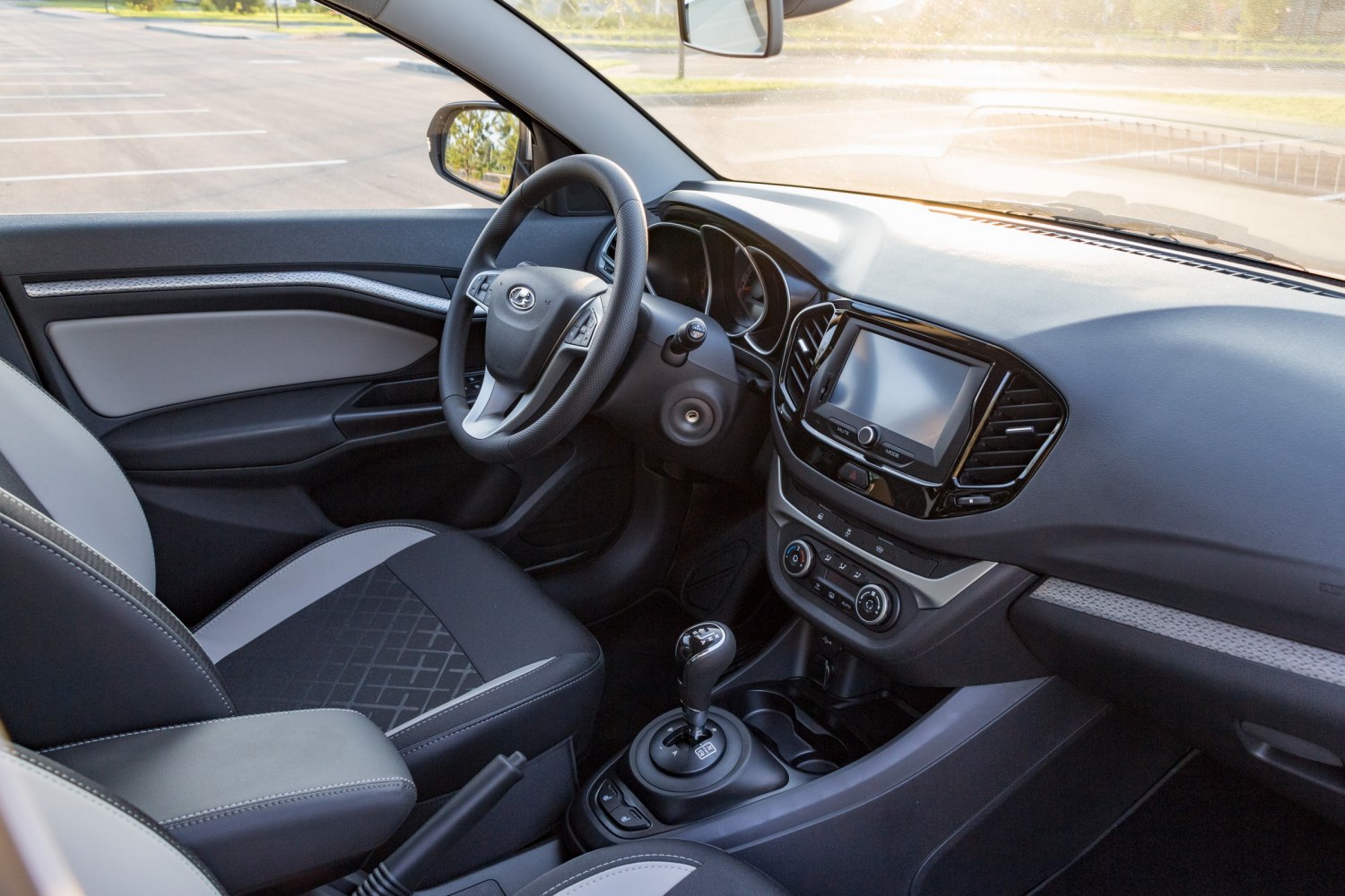 Modern car interior with touchscreen, steering wheel controls, and gear shift