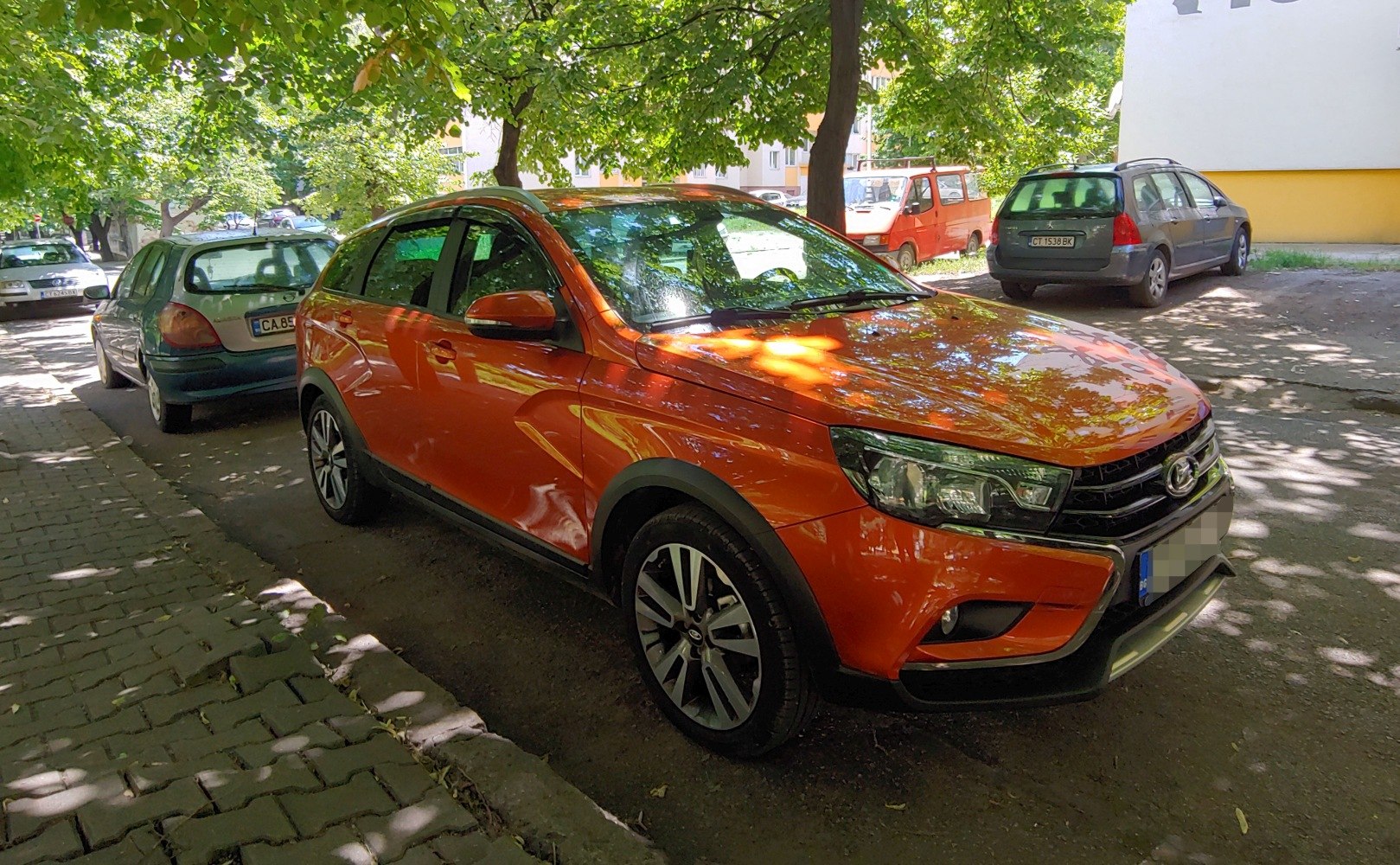 Orange compact crossover with sporty alloy wheels parked on urban street